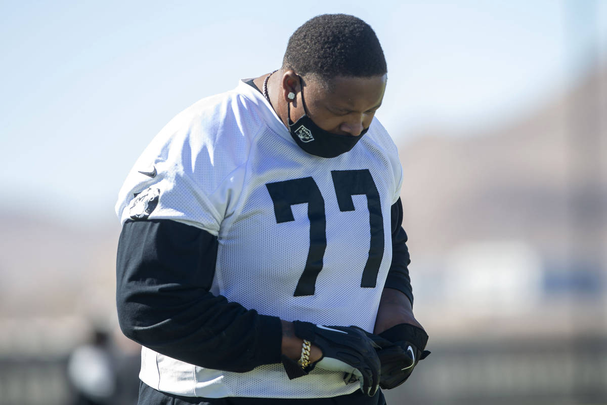 Las Vegas Raiders offensive tackle Trent Brown (77) warms up with a mask on during a practice ...