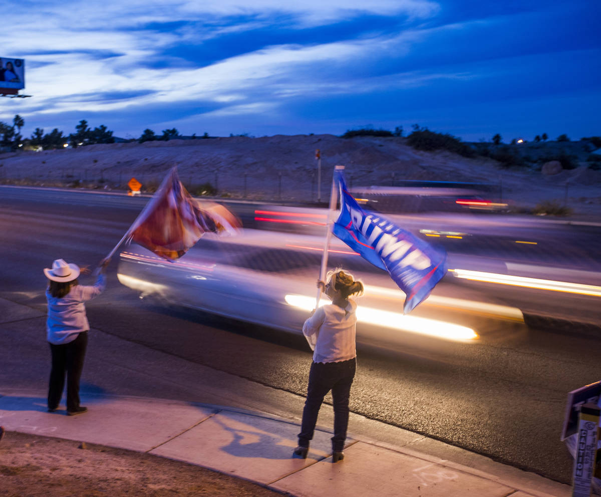 Victoria Giampa and Mary Ann Harden wave President Donald Trump flags along W. Cheyenne Ave. as ...