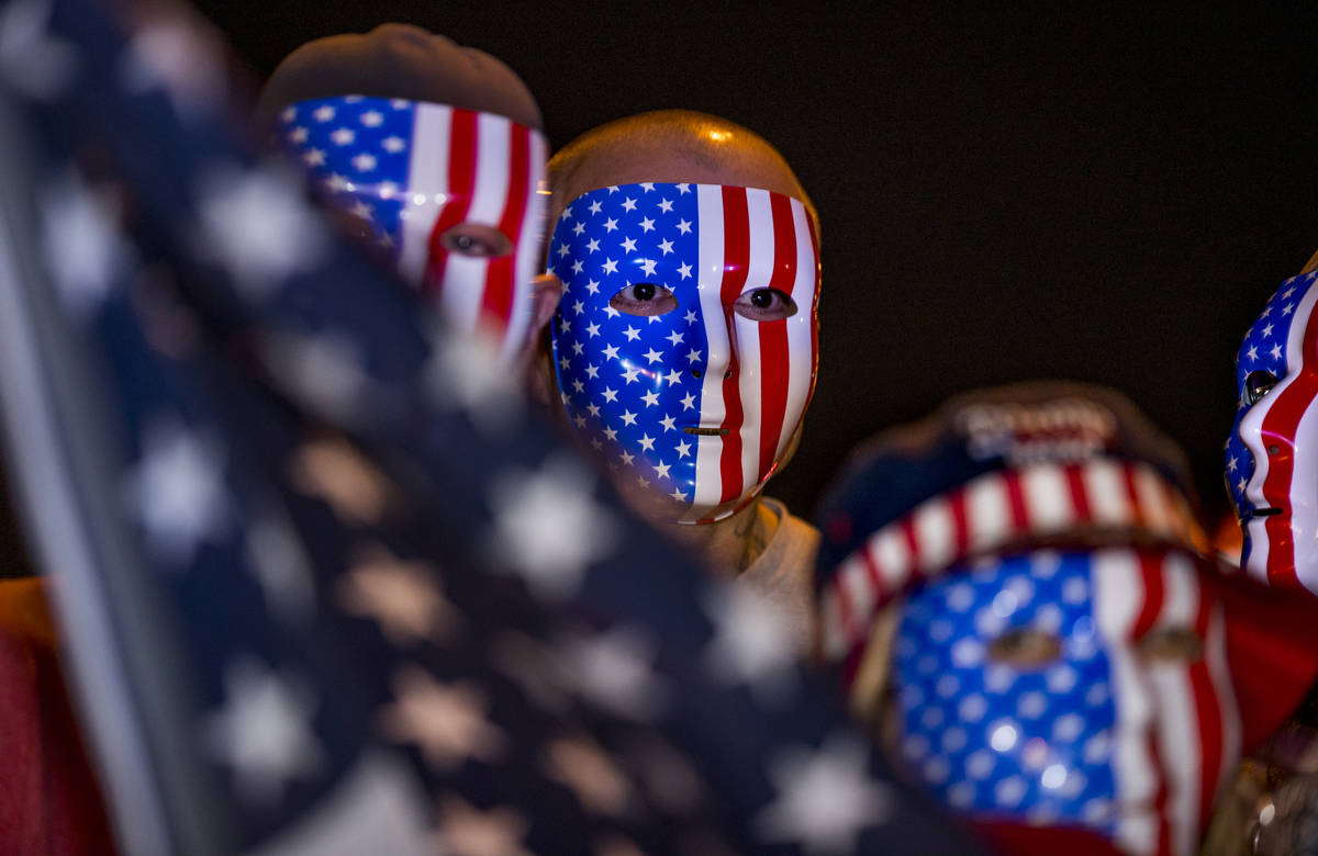 Four protesters in flag masks join in protests continuing outside the Clark County Election Dep ...