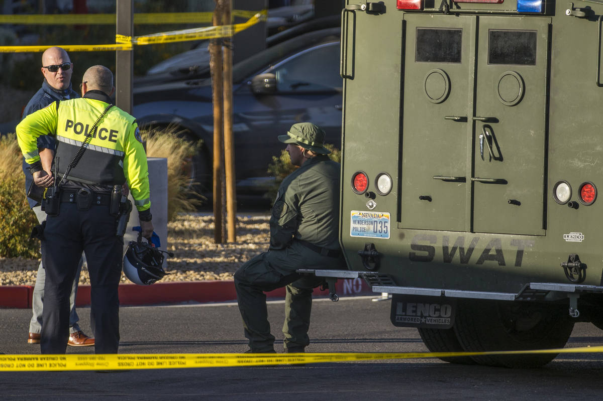 Emergency personnel as well as a SWAT vehicle about the parking lot after four were killed and ...