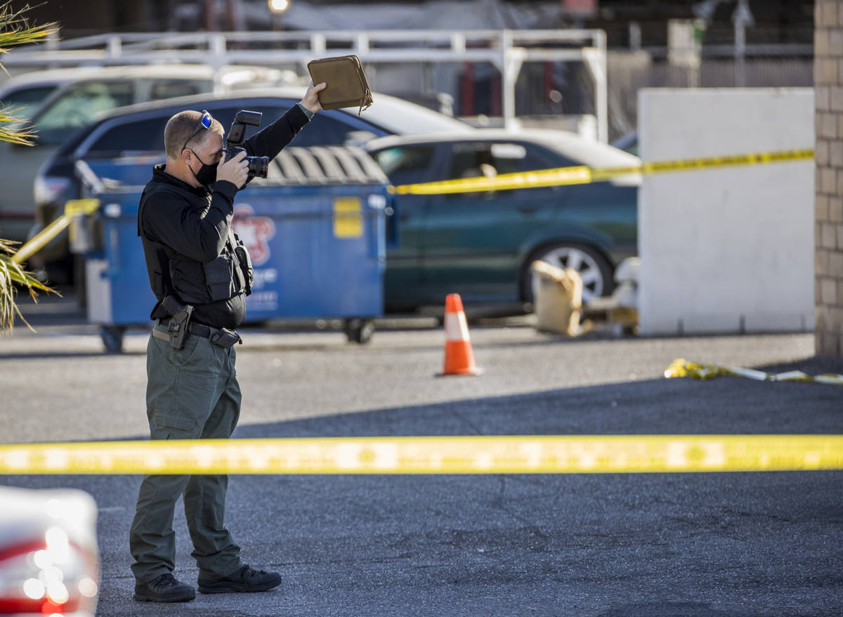 A crime scene investigator documents the scene as Las Vegas police investigate a homicide in th ...