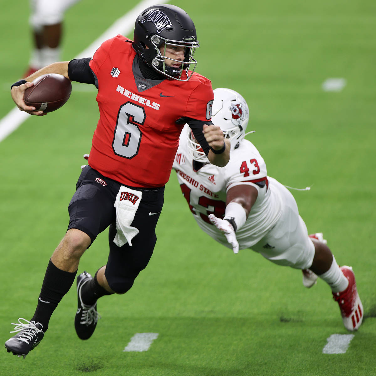 UNLV Rebels quarterback Max Gilliam (6) runs the ball under pressure from Fresno State Bulldogs ...