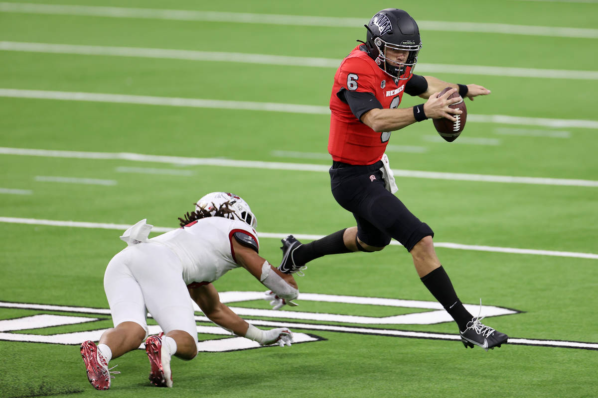 UNLV Rebels quarterback Max Gilliam (6) avoids a tackle against Fresno State Bulldogs linebacke ...