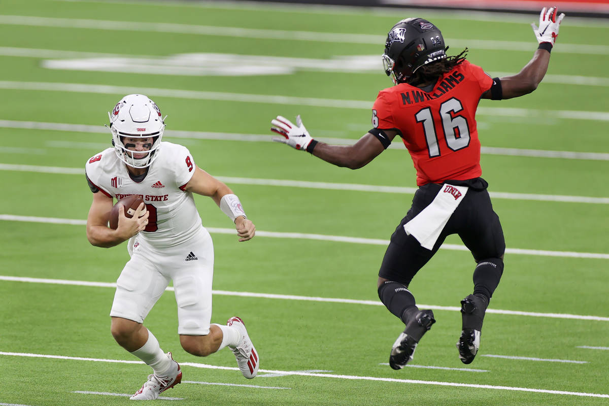 Fresno State Bulldogs quarterback Jake Haener (9) runs the ball against pressure from UNLV Rebe ...