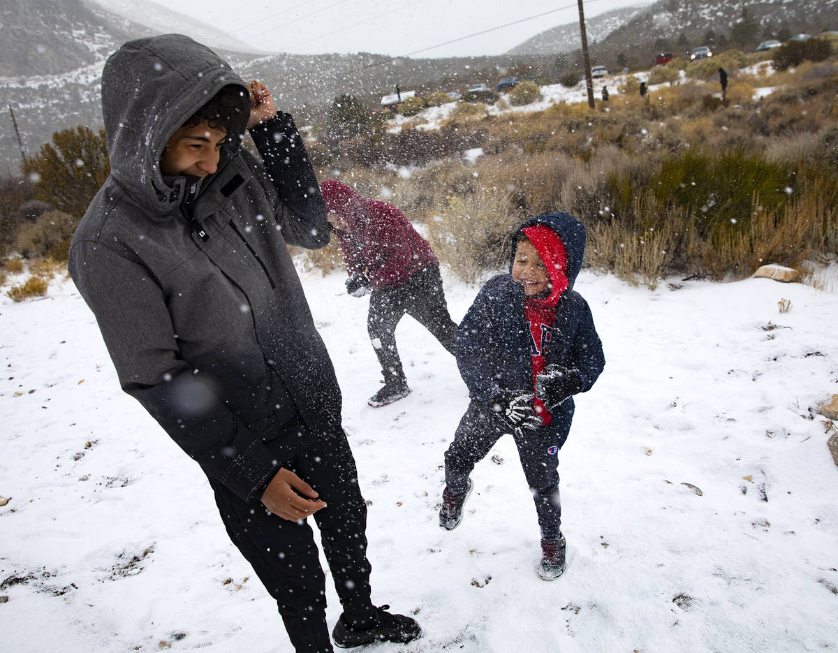 Joan Vasquez, 5, right, throws a snowball at his brother, Luis Vasquez, 15, left, as they play ...