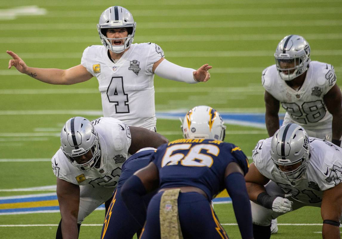 Las Vegas Raiders quarterback Derek Carr (4) calls an audible over Los Angeles Chargers linebac ...