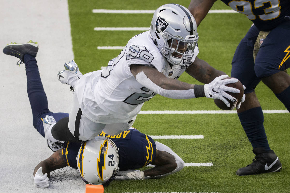 Las Vegas Raiders running back Josh Jacobs (28) leaps into the end zone over Los Angeles Charge ...