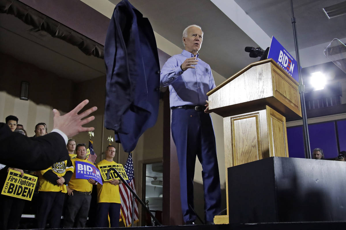 Former Vice President and Democratic presidential candidate Joe Biden tosses his jacket off sta ...