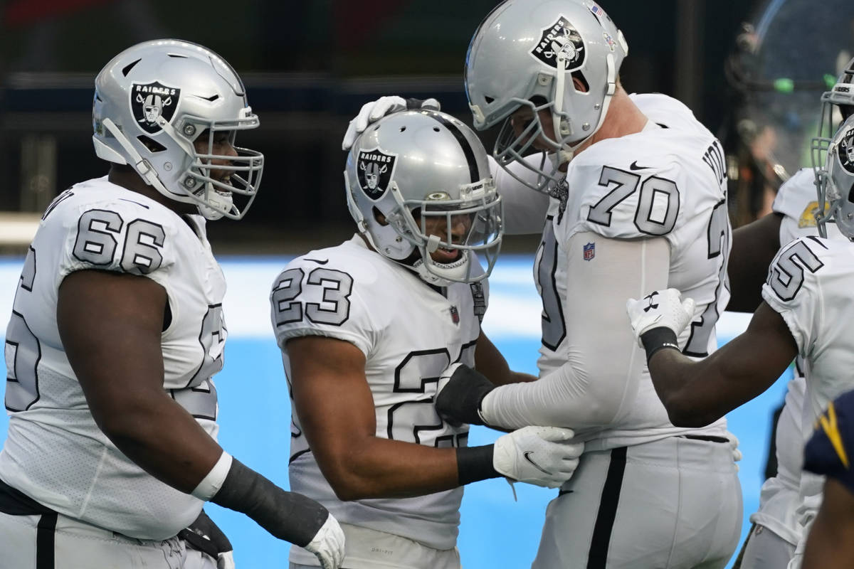 Las Vegas Raiders running back Devontae Booker (23) reacts with teammates offensive tackle Sam ...