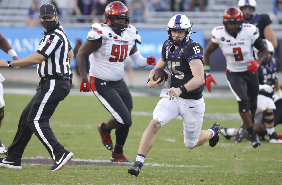 TCU quarterback Max Duggan (15) carries the ball for a first down past Texas Tech defensive lin ...