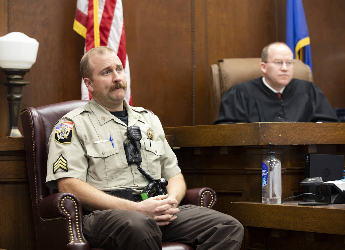 Sgt. Nathan Mingo, left, gives testimony as Justice of the Peace Mason Simons listens at a prel ...