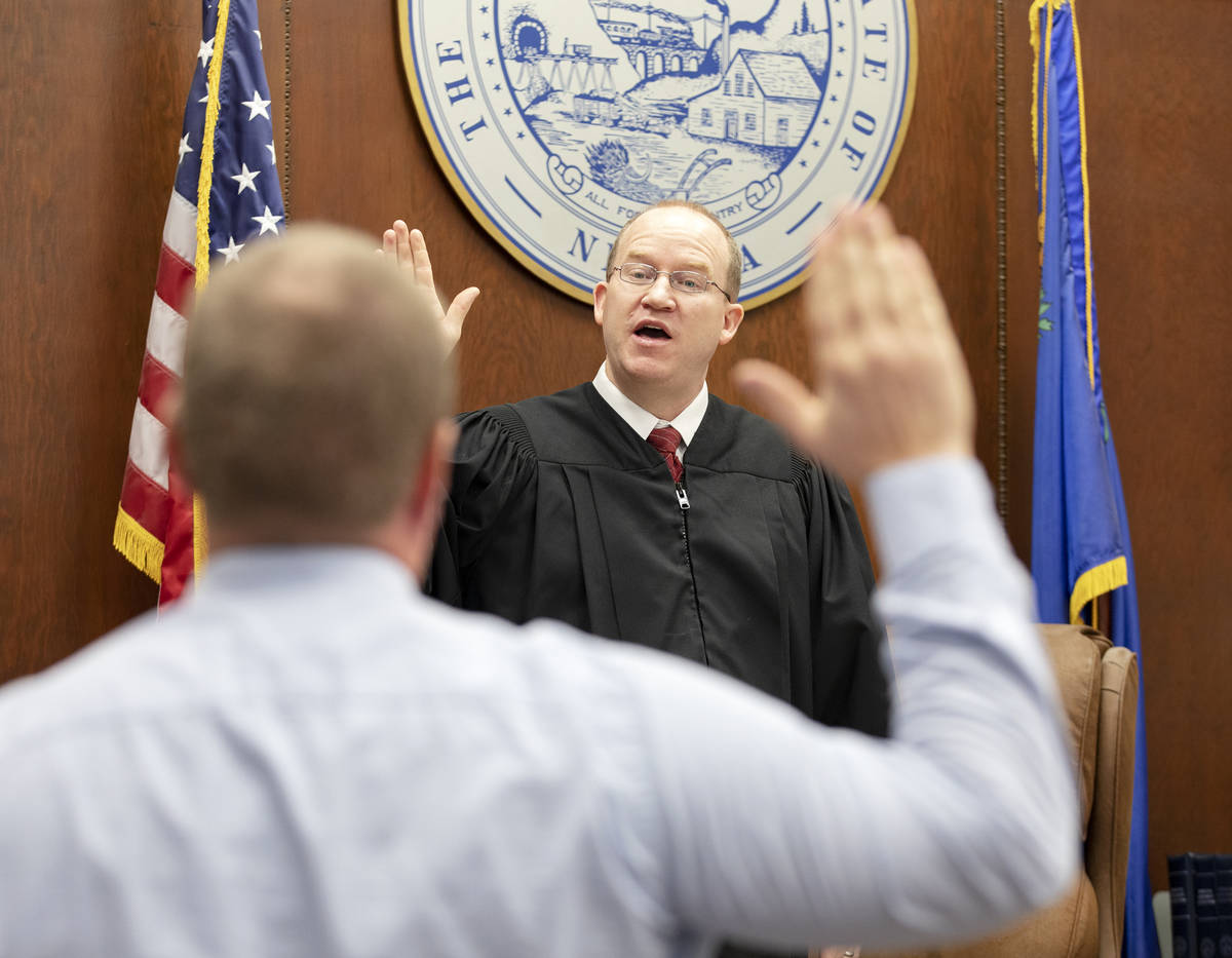 Justice of the Peace Mason Simons swears in Detective Jeremiah Peterson of the White Pine Count ...