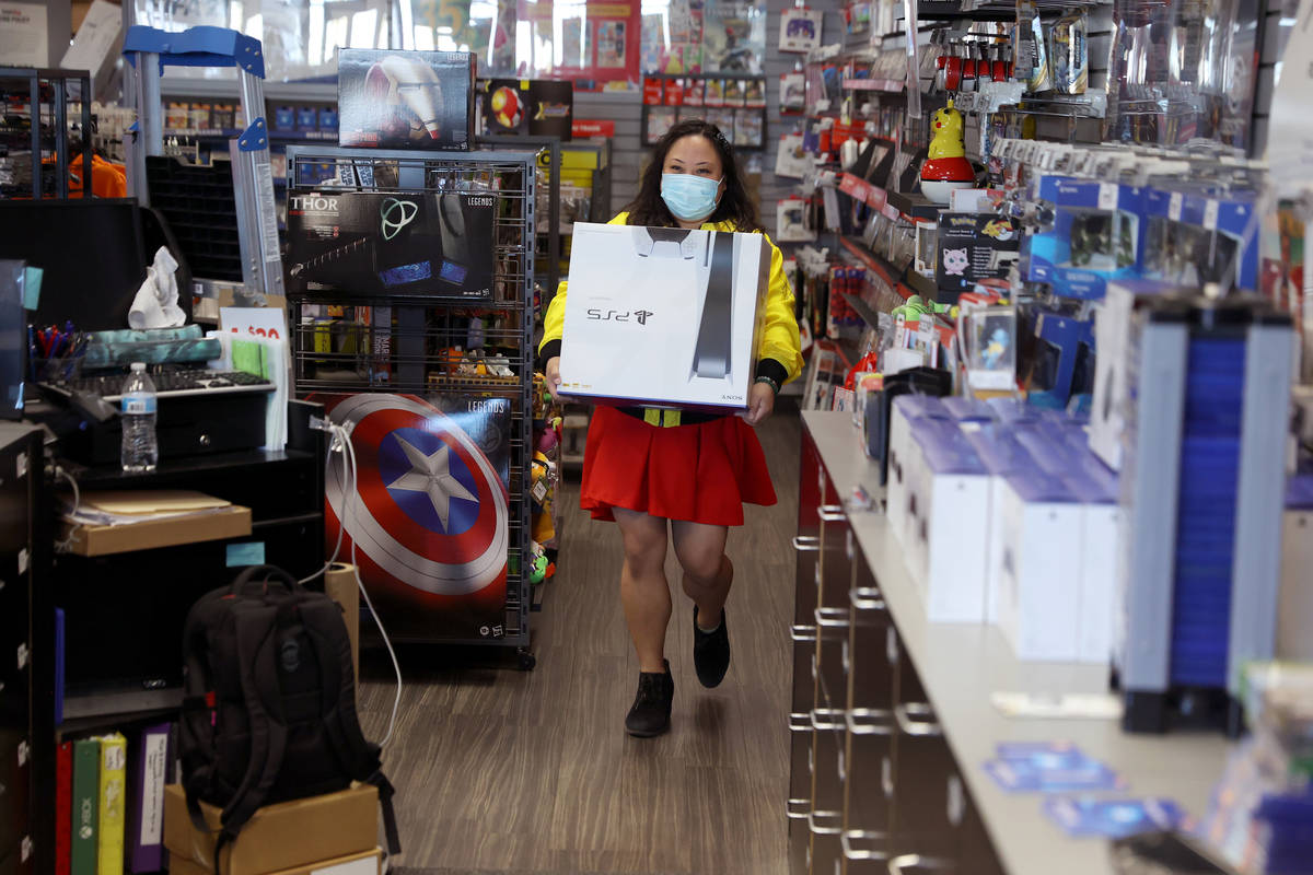 Jane Esposo retrieves a Play Station 5 for a costumer at GameStop, 9975 S Eastern Ave., in Las ...