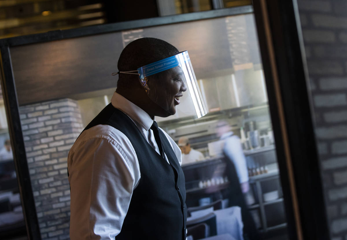 Donald Bailey wears a face shield while serving diners at Nora's Italian Cuisine in Las Vegas o ...