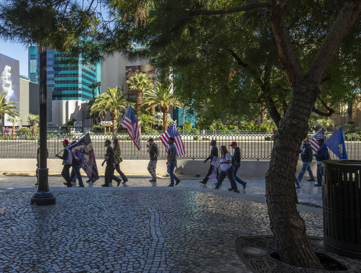 A group moves past New York-New York during a Veterans Day march to peacefully protest Governor ...