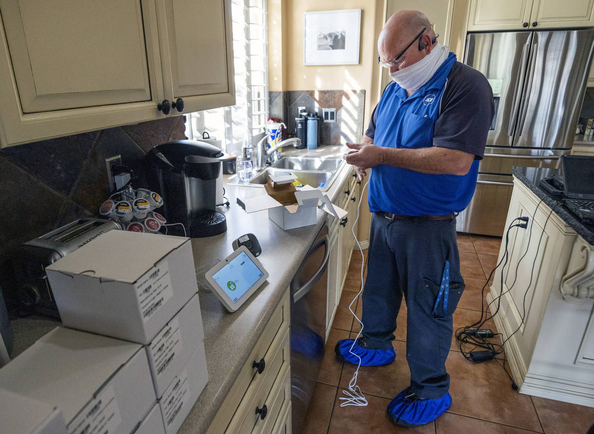 ADT Custom Home Services field service technician Paul Keplinger installs a security system in ...