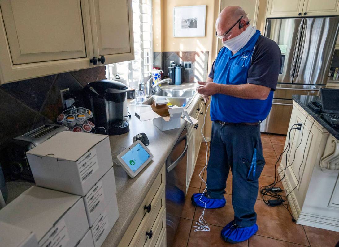 ADT Custom Home Services field service technician Paul Keplinger installs a security system in ...