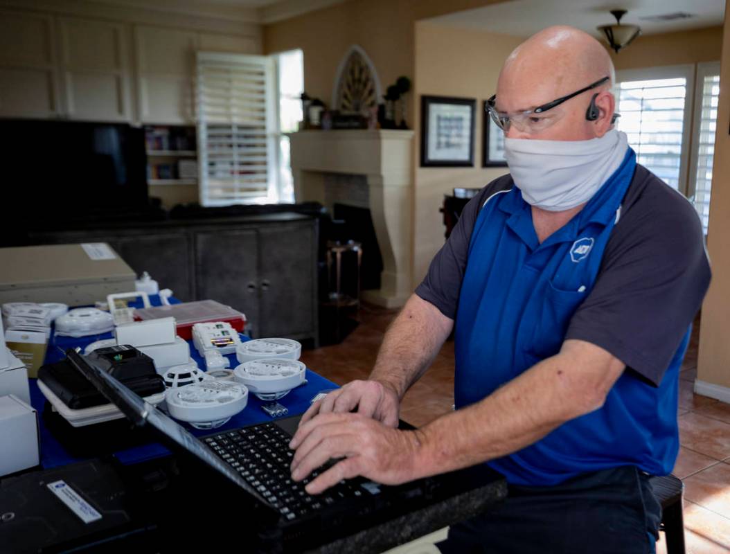 ADT Custom Home Services field service technician Paul Keplinger installs a security system in ...