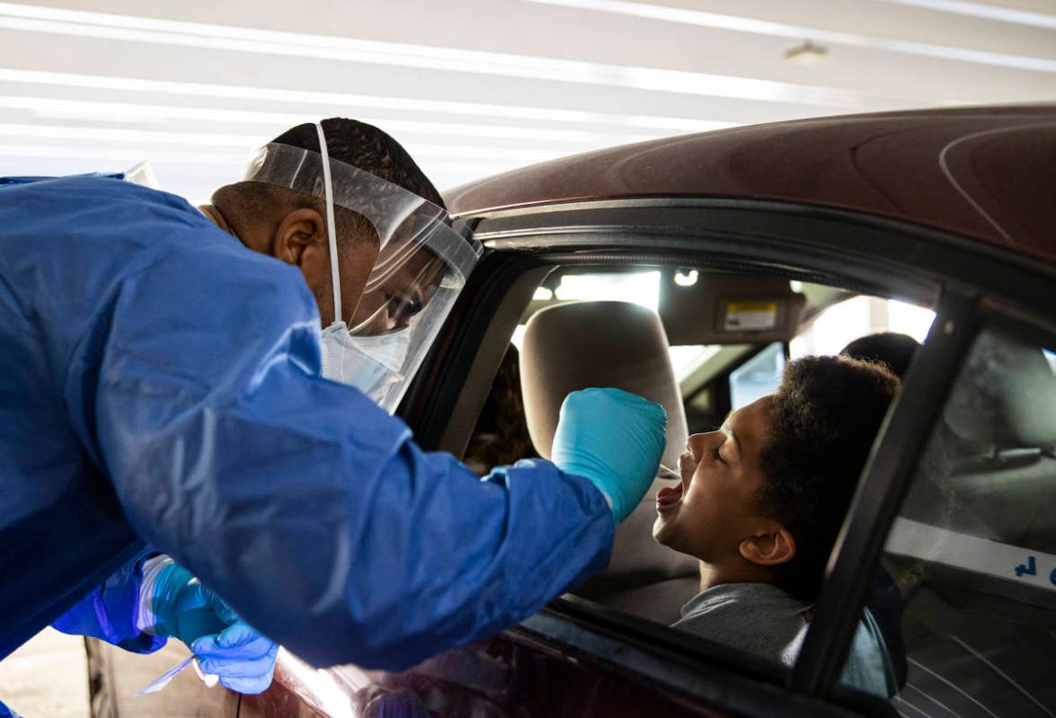 Nevada National Guard Spc. Demetrie Barnett takes a swab sample from Uriyah Smith, 11, of North ...