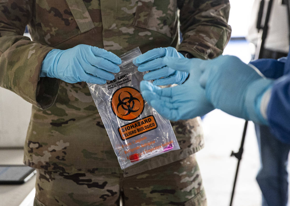 Nevada National Guard specialists Jonathan Macias, left, and Demetrie Barnett store a test tube ...