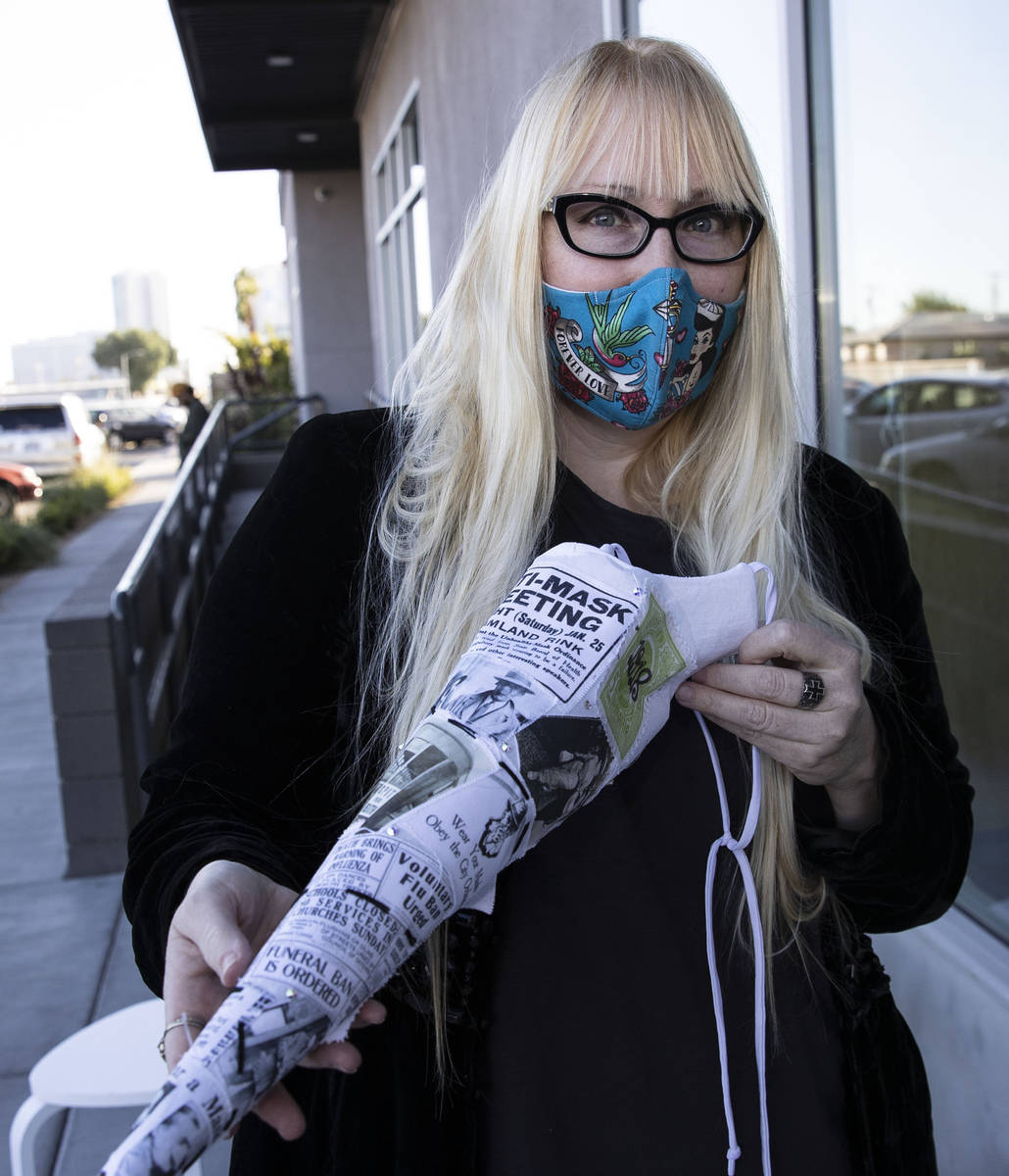 A local fashion designer, Anna Bartoletti, shows off her "Full Circle" mask as she ...