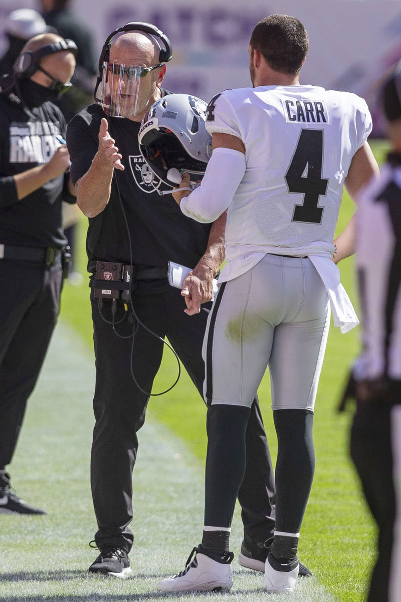 Las Vegas Raiders offensive line coach Tom Cable speaks to quarterback Derek Carr (4) during th ...