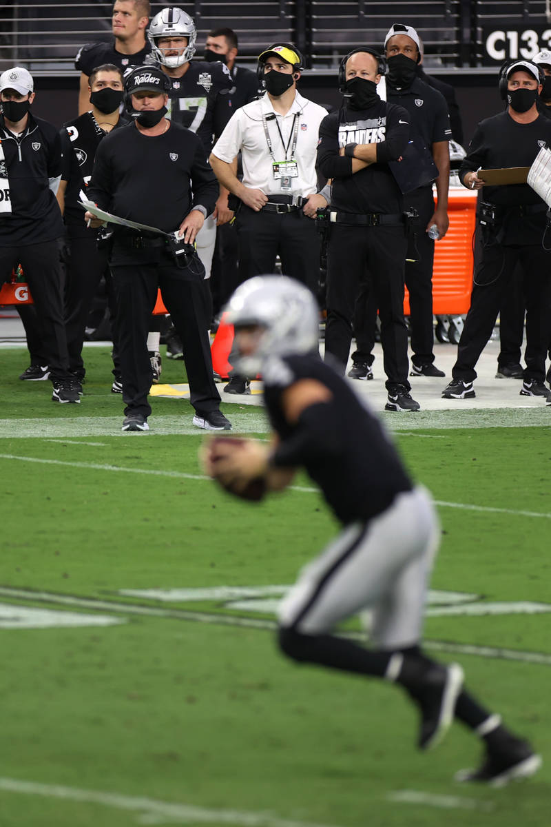 The Las Vegas Raiders bench including heat coach Jon Gruden watch quarterback Derek Carr (4) ru ...