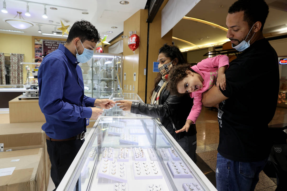 Bennie Hollis, right, his wife Diana and daughter Jasmine, 2, shop with sales associate Kevin S ...