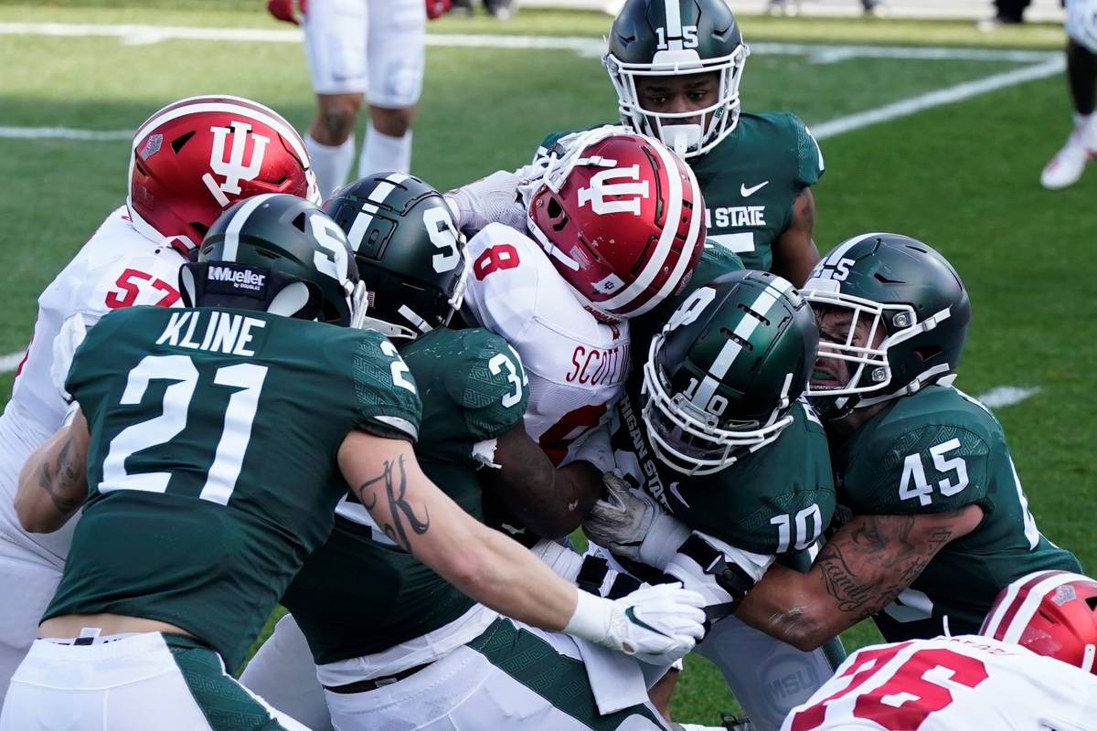 Indiana running back Stevie Scott III (8) is tackled by the Michigan State defense as he falls ...