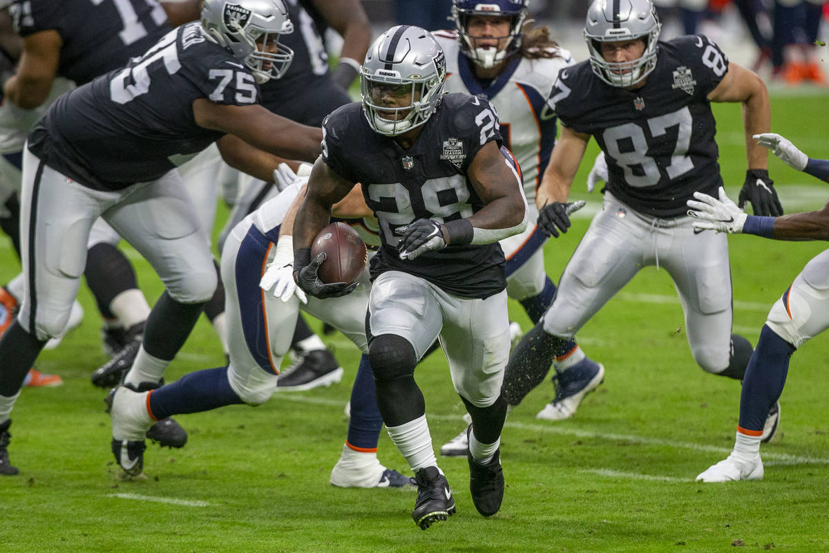 Las Vegas Raiders running back Josh Jacobs (28) runs with the football against the Denver Bronc ...