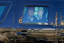 President Donald Trump waves to supporters from his motorcade as people gather for a march Satu ...