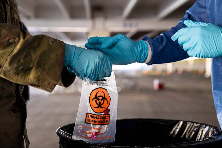 Nevada National Guard specialists Jonathan Macias, left, and Demetrie Barnett store a test tube ...