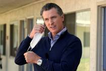 Gov. Gavin Newsom removes his face mask before giving an update during a visit to Pittsburg, Ca ...
