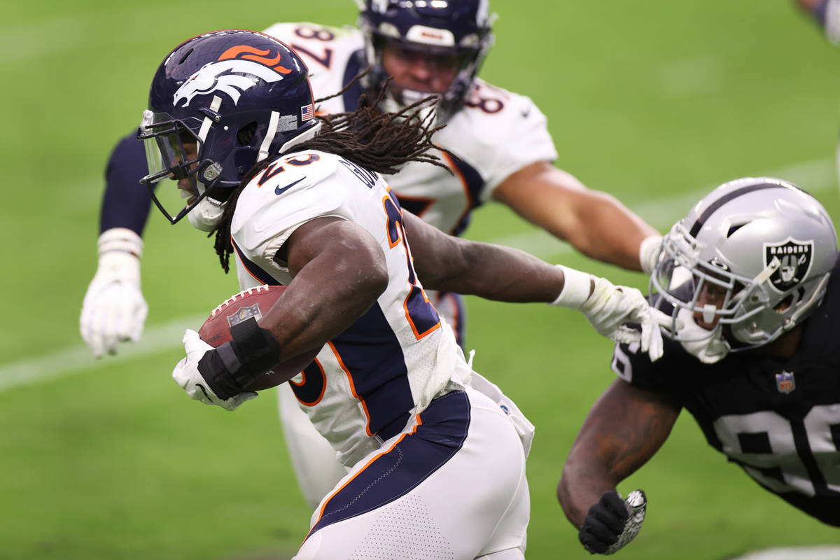 Denver Broncos running back Melvin Gordon (25) breaks a tackle from Las Vegas Raiders defensive ...