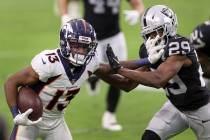 Denver Broncos wide receiver K.J. Hamler (13) stiff arms Las Vegas Raiders free safety Lamarcus ...