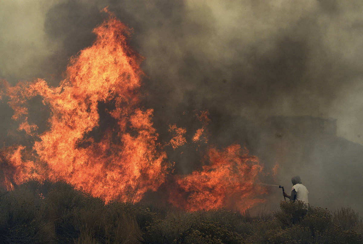 Homeowner Steven Phelps battles the Pinehaven Fire in the Caughlin Ranch area of Reno, Nev., on ...