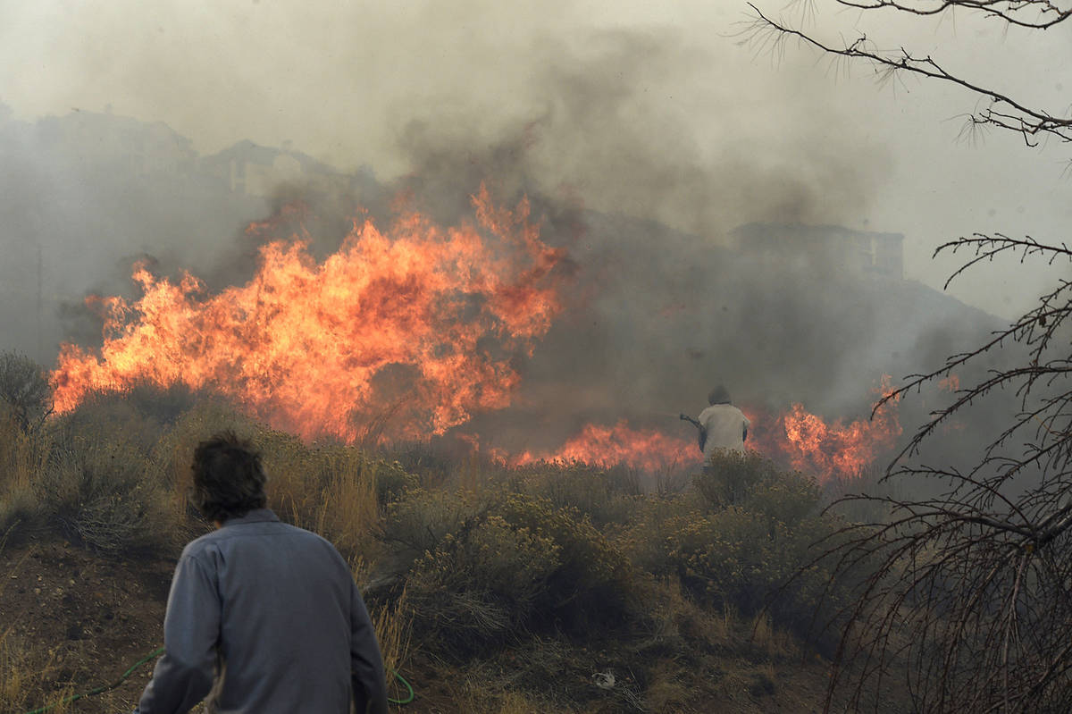 Homeowner Steven Phelps, right, and his son Richard battle the Pinehaven Fire in the Caughlin R ...