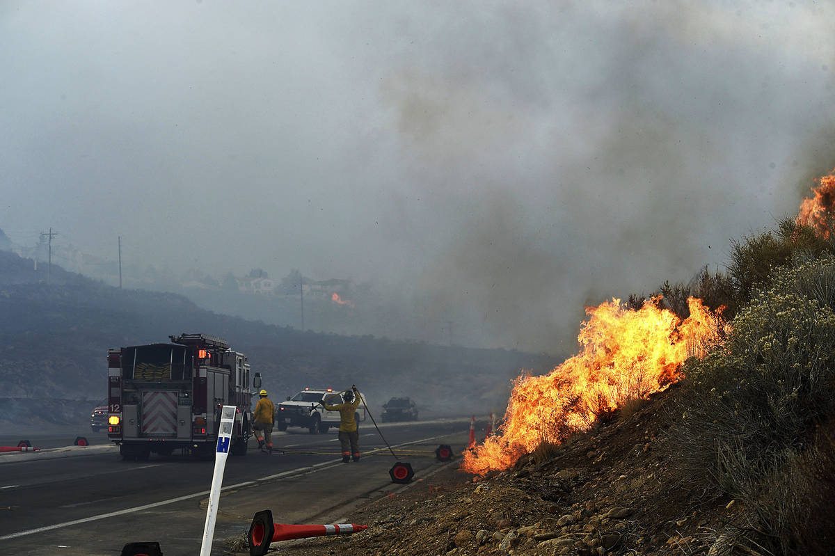 Firefighters battle the Pinehaven Fire in the Caughlin Ranch area of Reno, Nev., on Tuesday, No ...