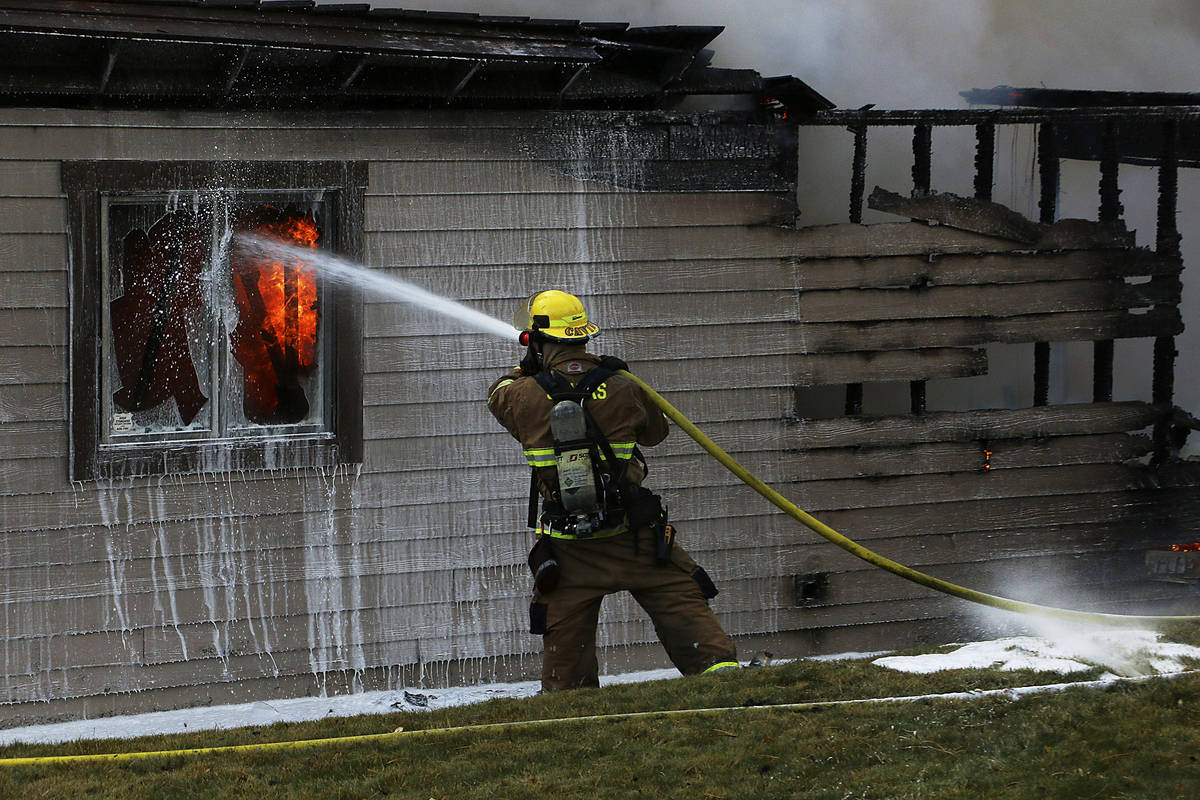 A firefighter tries to save a home during the Pinehaven Fire in the Caughlin Ranch area of Reno ...