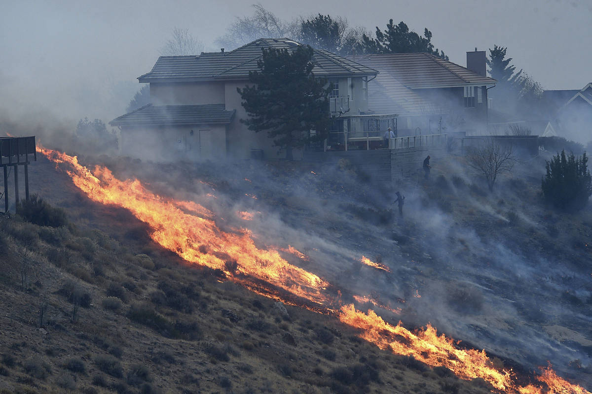People try to protect their homes during the Pinehaven Fire in the Caughlin Ranch area of Reno, ...