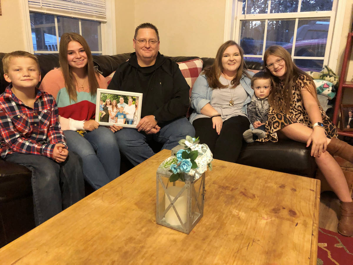 Keith Michael, third from left, sits on a sofa with his children, from left, Hunter, Jessica, S ...