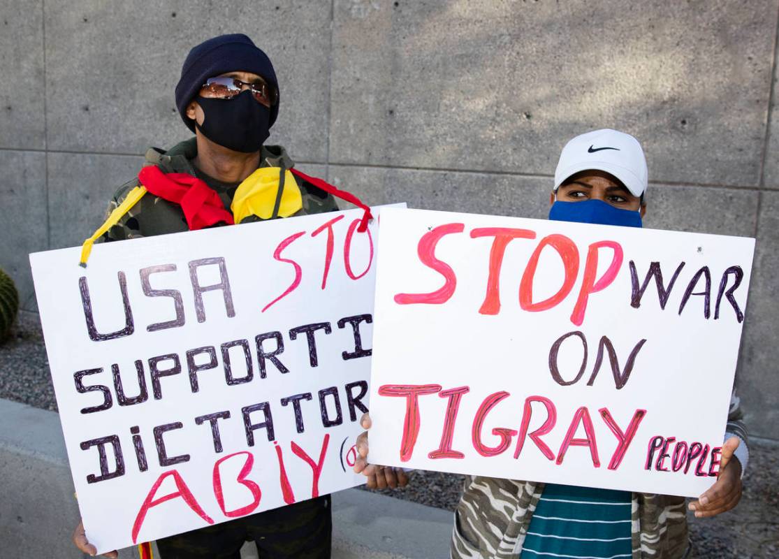 Samson Araya, left, and Senait Negussie hold signs outside of the Lloyd D. George Federal Court ...