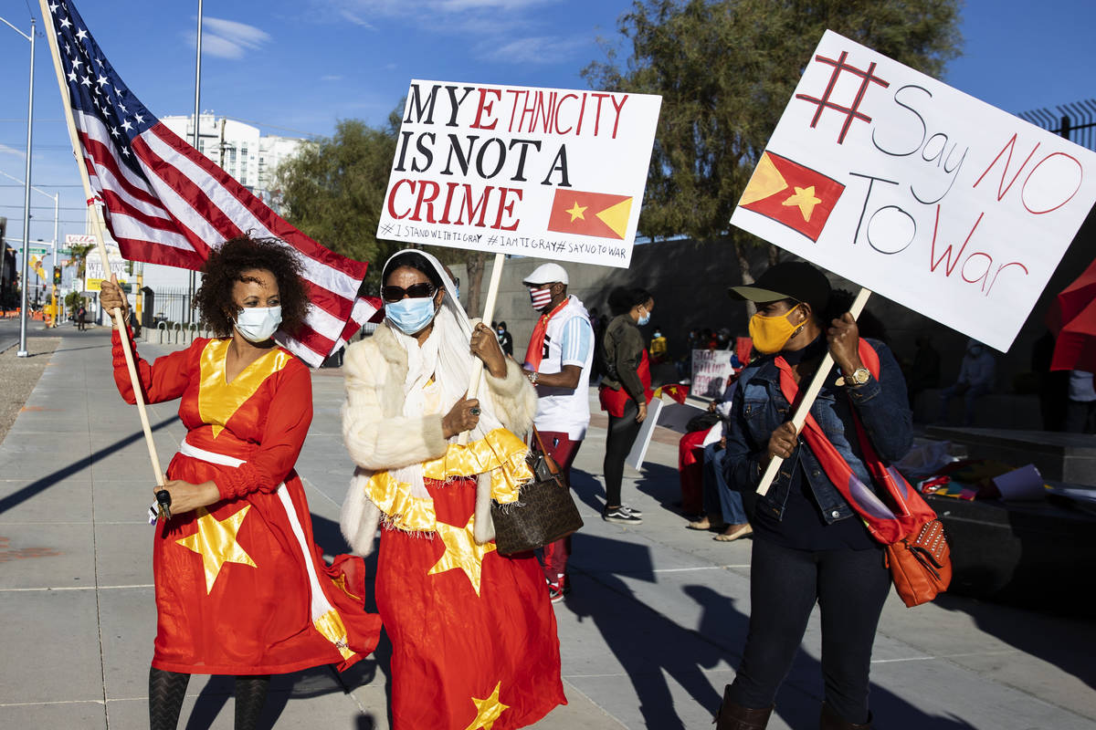 Alem Kahsay Woldemicael, left, Gene Abegas and Masho Teklay hold signs outside of the Lloyd D. ...