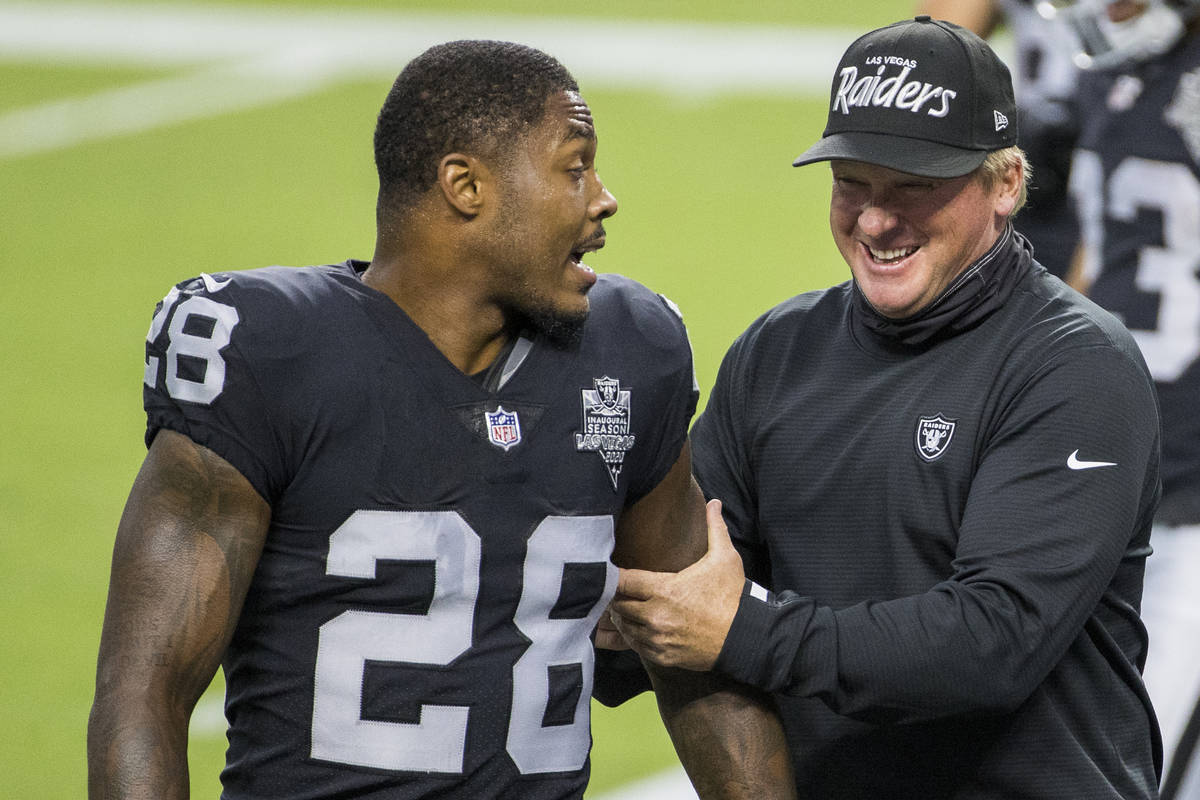 Las Vegas Raiders running back Josh Jacobs (28, left) jokes around with head coach Jon Gruden d ...