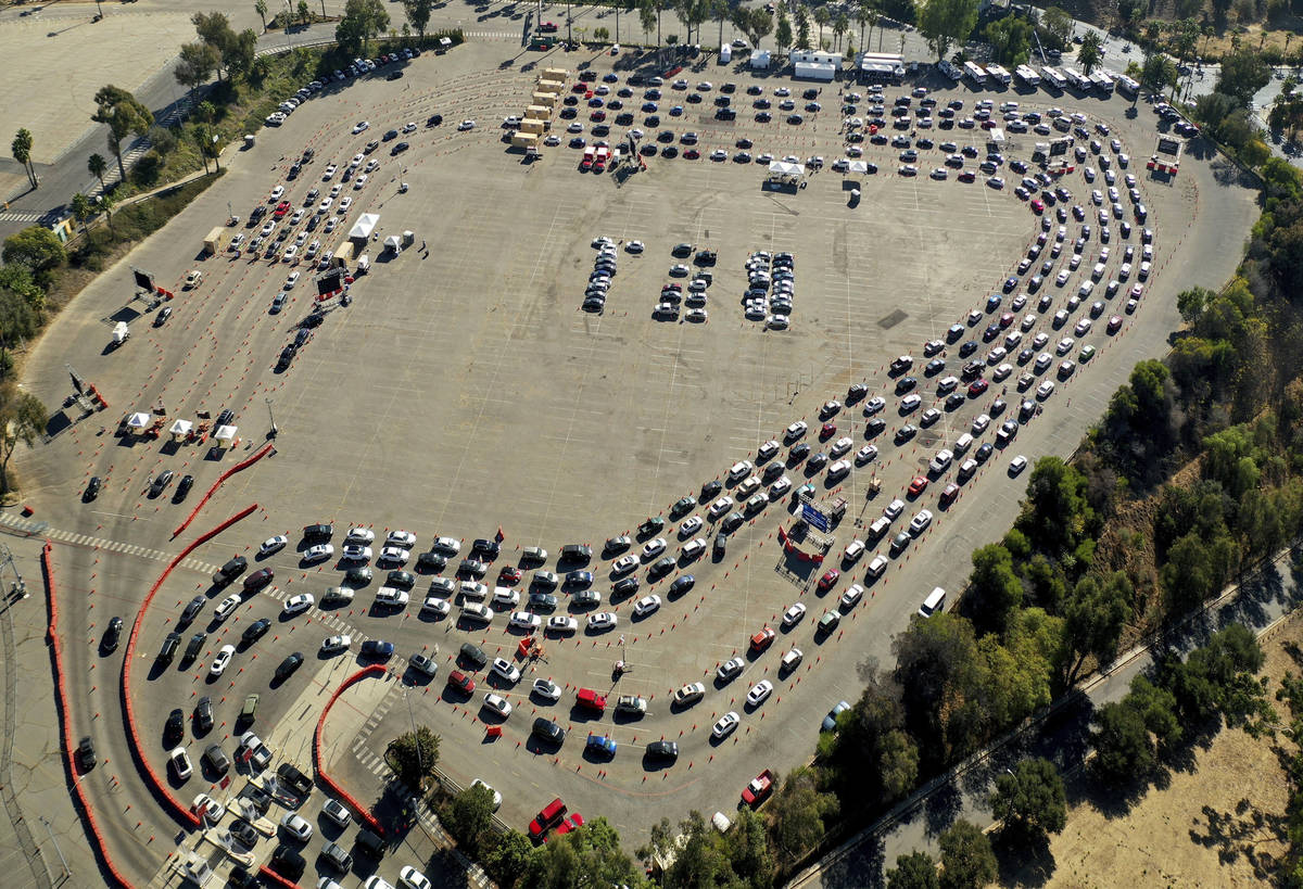 In this Nov. 17, 2020, file photo, drivers wait in long lines at a COVID-19 testing site in a p ...