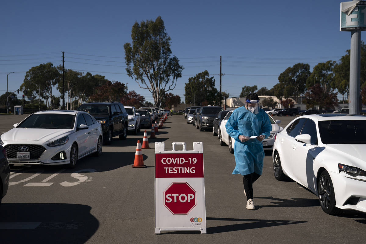 FILE - In this Nov. 16, 2020, file photo, student nurse Ryan Eachus collects forms as cars line ...