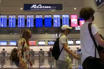 In this June 24, 2020, file photo, travelers walk past McCarran International Airport sign in L ...