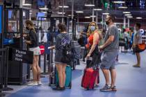 Passengers make their way through the TSA checkpoint in Terminal 1 as COVID-19 safety precautio ...