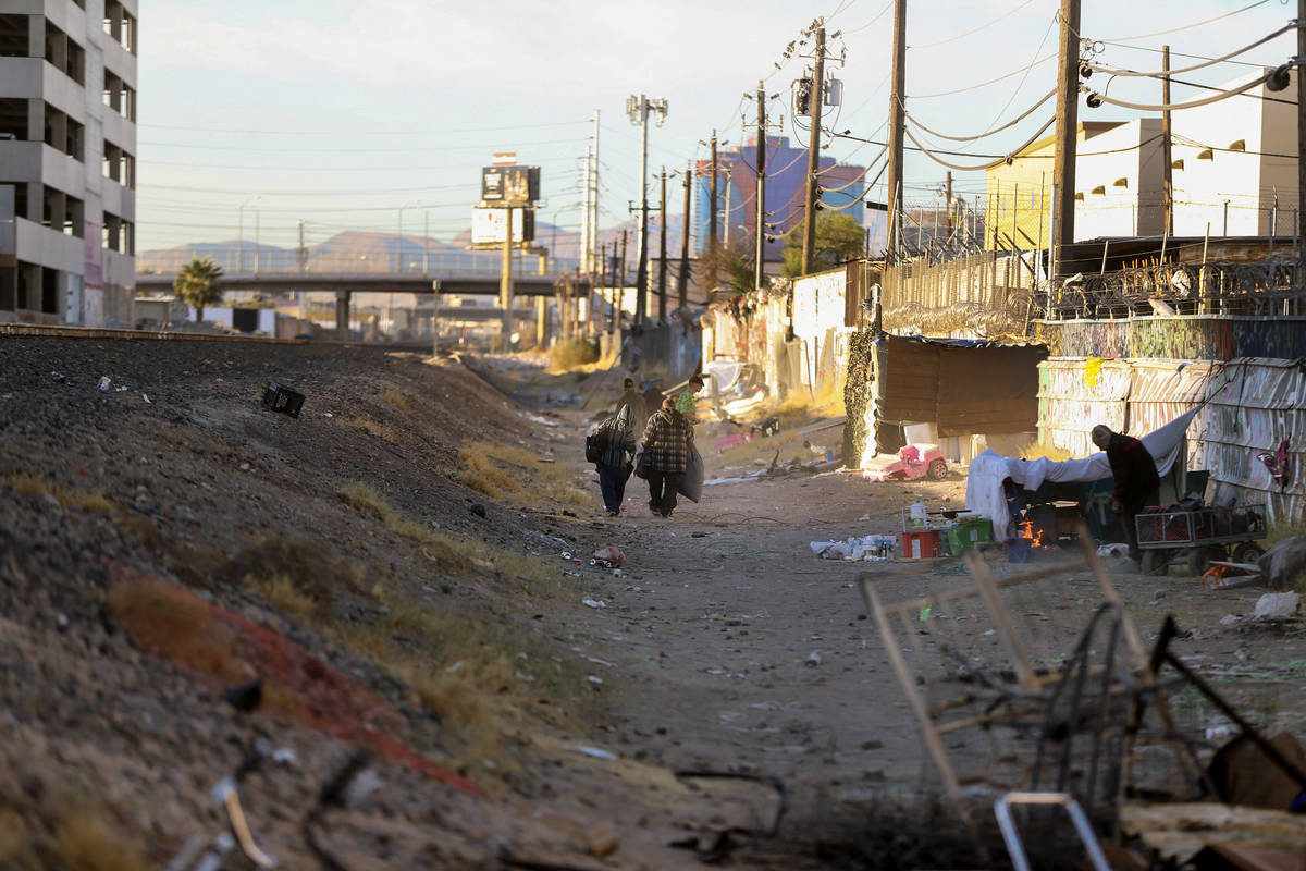 People walk along the train tracks near Oakey Boulevard and Highland Drive in Las Vegas on Nov. ...