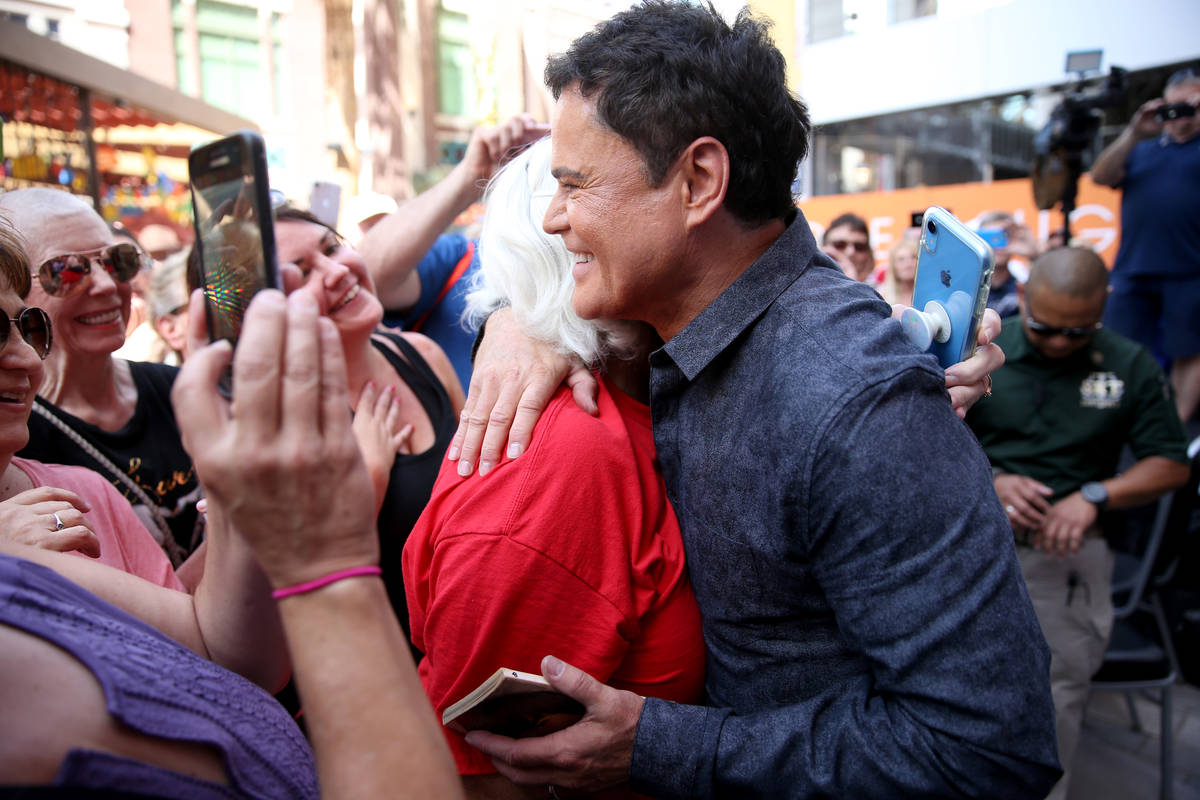 Strip headliner Donny Osmond hugs Kim Lemons of Sterling, Okla. after receiving a Key to The La ...